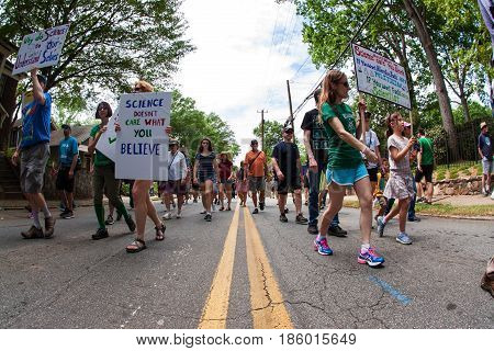 ATLANTA, GA - APRIL 22:  People carry signs as they march on Earth Day in the Atlanta March for Science near Candler Park in Atlanta GA on April 22 2017.