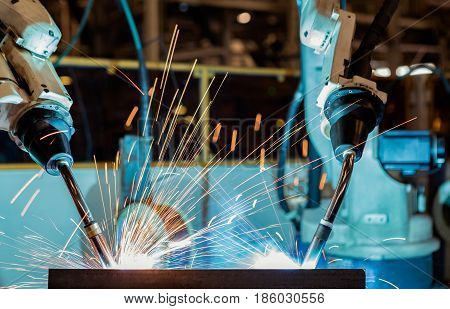 Close up team robots are welding in factory