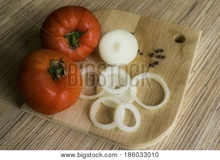 Sliced Onion, Whole Tomato And Black Pepper On Oak Cutting Board