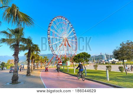 Batumi, Georgia - April 30, 2017: Ferris wheel, city panoramic landscape with port and mountain peaks of Batumi, summer Black sea resort