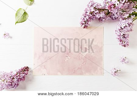 An arrangement of spring lilac flowers and an abstract watercolor background