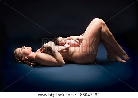 Naked woman lying on her back with baby on her stomach