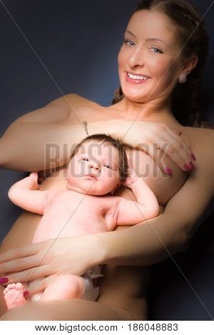 Naked woman lying on her back with baby on her stomach