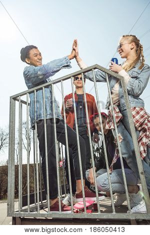 Teenagers Having Fun And Giving Highfive In Skateboard Park, Hipster Style Concept