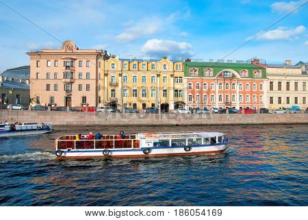 SAINT - PETERSBURG, RUSSIA - MAY 11, 2017: Excursion boats with tourists sail along colorful resudential houses on the embankment of The Fontanka River