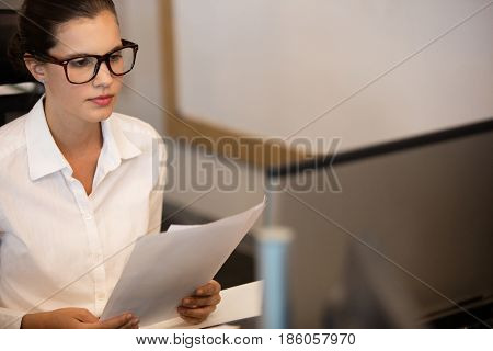 Young businesswoman reading documets at office