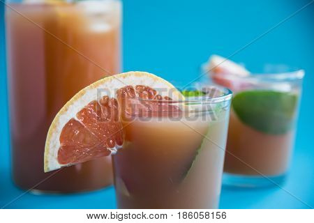 Grapefruit alcoholic cocktail with pieces of fruit, ice and mint