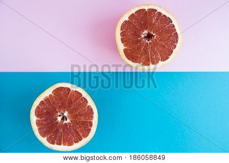 Cut in half a grapefruit on a pink and blue background