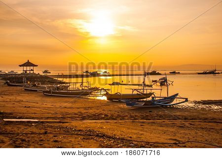 Traditional Balinese Boats And Pavilion In Sanur Beach In The Morning At Dawn, Bali, Indonesia.