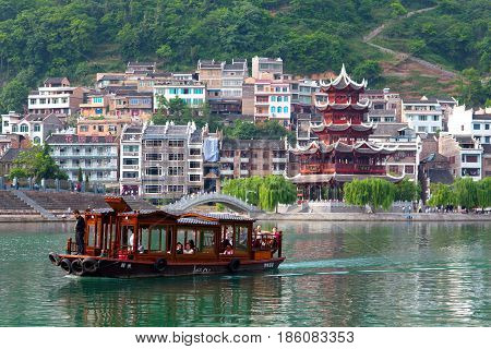 Zhenyuan, China - May 2, 2014: Tourists floating on the boat on Wuyang River in ancient town Zhenyuan of Guizhou Province.