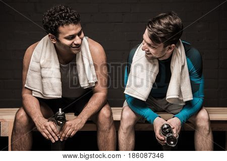Handsome Male Athletes Resting And Conversing At Gym Locker Room