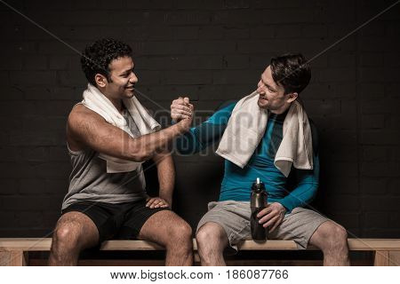 Handsome Male Athletes Resting And Conversing At Gym Locker Room