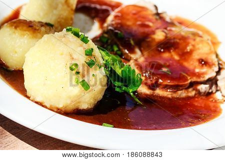 Traditional German Bavarian roast pork with sauce and potato dumplings