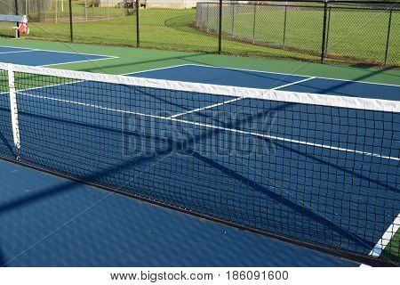 empty Pickleball playing ball court with net and blue courts
