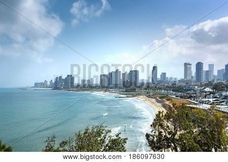 Tel Aviv skyline by day with beach sea and waves