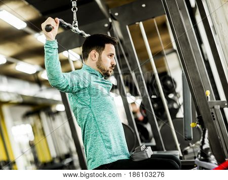 Young Man Doing Exercise For Triceps In The Gym On Mashine