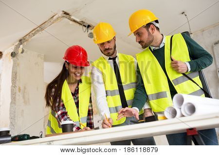 Three Arhitects Working Together On Construction Site Project