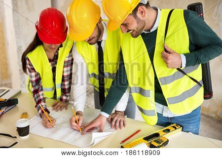 Three Arhitects Working Together On Construction Site Project