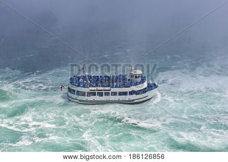 The boat with tourists eager to see the nature miracle in front of Niagara Bridal Veil Falls.