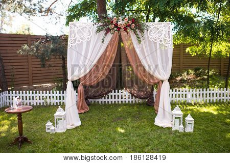Beautiful Wedding Ceremony Outdoors. Decorated Chairs Stand On The Grass. Wedding Arch Made  Flowers