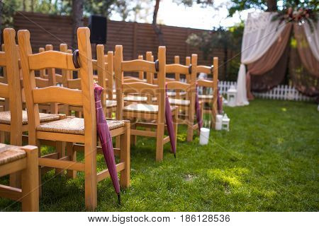 Beautiful Wedding Ceremony Outdoors. Decorated Chairs Stand On The Grass. Wedding Arch Made  Flowers
