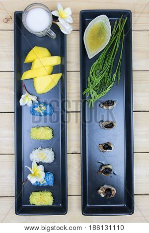 Mango and rice with coconutmilk and Obsters with sauce on wooden tablehigh angle background