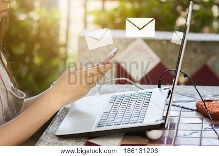 Hand hold cell phone send e-mail to computer