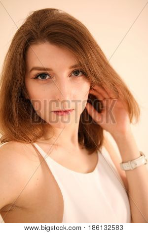 Portrait of attractive young woman with long brown hair posing isolated on white background. Perfect face for your company