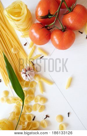 Many kinds of pasta and vegetables on white background