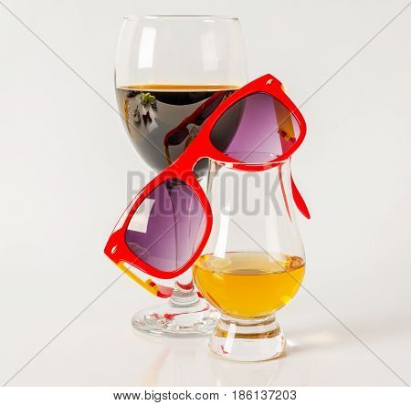 Set of single malt tasting glass and wineglass sunglasses single malt whiskey and red wine in a glass white background party set