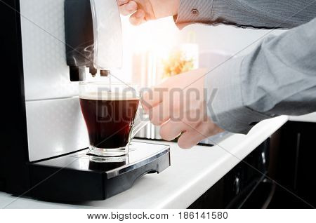 Man Making Black Coffee In Glass With Coffee Machine