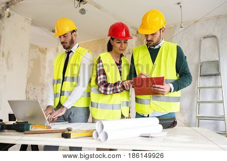 Three Arhitects Working Together On Construction Site Project