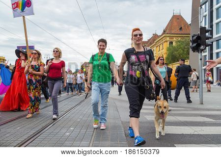 ZAGREB, CROATIA - JUNE 11, 2016: 15th Zagreb pride. LGBTIQ activists walking the dog decorated with rainbow colors.