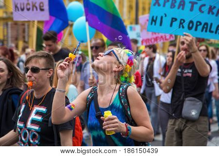 ZAGREB, CROATIA - JUNE 11, 2016: 15th Zagreb pride. LGBTIQ activist blowing soap bubbles.
