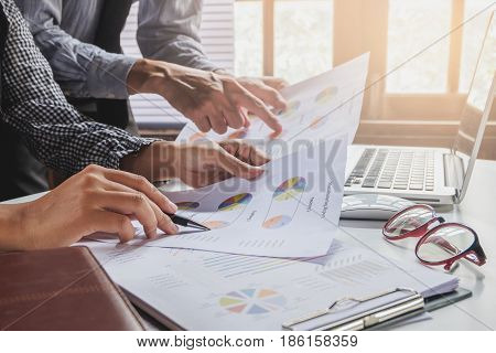Image of two young business team using laptop computer and graph financia at meeting.Close up business team analysis and strategy concept.