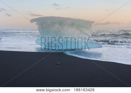 Ice breaking from glacier on black sand beach Iceland winter season natural landscape background