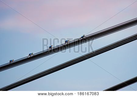 young brave woman roofer in the evening climing on the bridge
