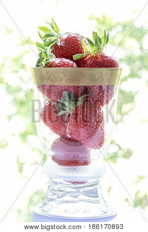 Strawberries In A Glass Cup On A Colored Background