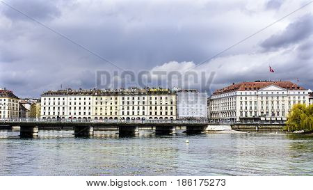 View Of The Mont Blanc Bridge From The Lake Promenade With The Hotel Des Bergues In The Background