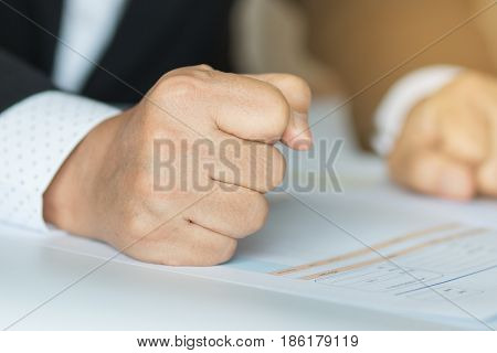 business people hand banging fist with angry on table problems stress workplace desk at office