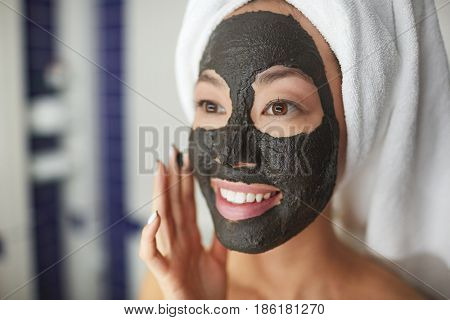 Closeup portrait of beautiful Asian woman applying face mask