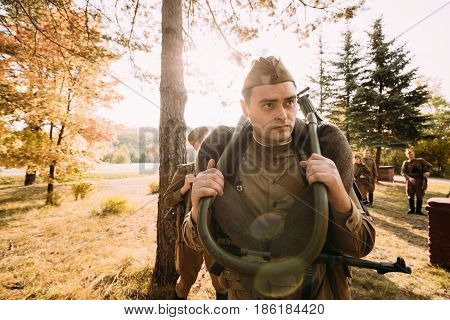 Dyatlovichi, Belarus - October 1, 2016: Reenactor Man Dressed As Russian Soviet Red Army Infantry Soldier Of World War II Preparing For Marching In Forest With Machine-gun At Historical Reenactment