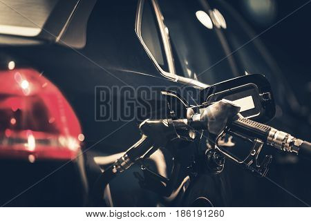 Gasoline Car Refueling Closeup Photo. Night Time Vehicle at the Gas Station.