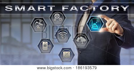 Male blue chip plant manager activating a Smart Factory application. Technology concept for digital manufacturing cyber physical systems industry 4.0 and data exchange via internet of things.