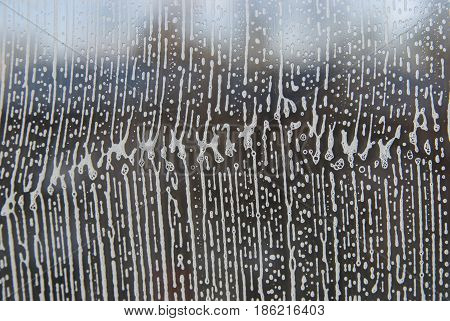 Cleaning background texture - chemical soap detergent foam on a clear glass.