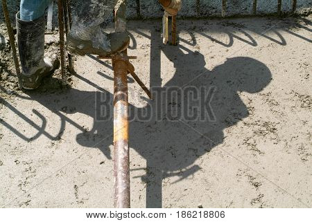Bissone Switzerland - 10 August 2010: Street worker pouring cement with a pump into a highway construction