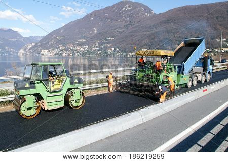 Workers And Vehicles During The Asphalting Of The Highway