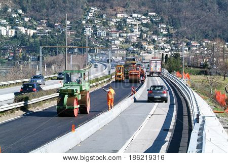 Workers And Vehicles During The Asphalting Of The Highway