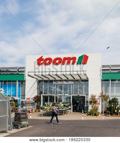 FRANKFURT GERMANY - APR 1 2017: Black ethnicity woman walking to the entrance of TOOM the German DIY-store chain offering home improvement and do-it-yourself goods - customers buying goods selecting the best tools