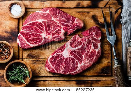 Meat. Two raw beef marbled meat steak on wooden cutting board, meat carving set, rustic background. Top view